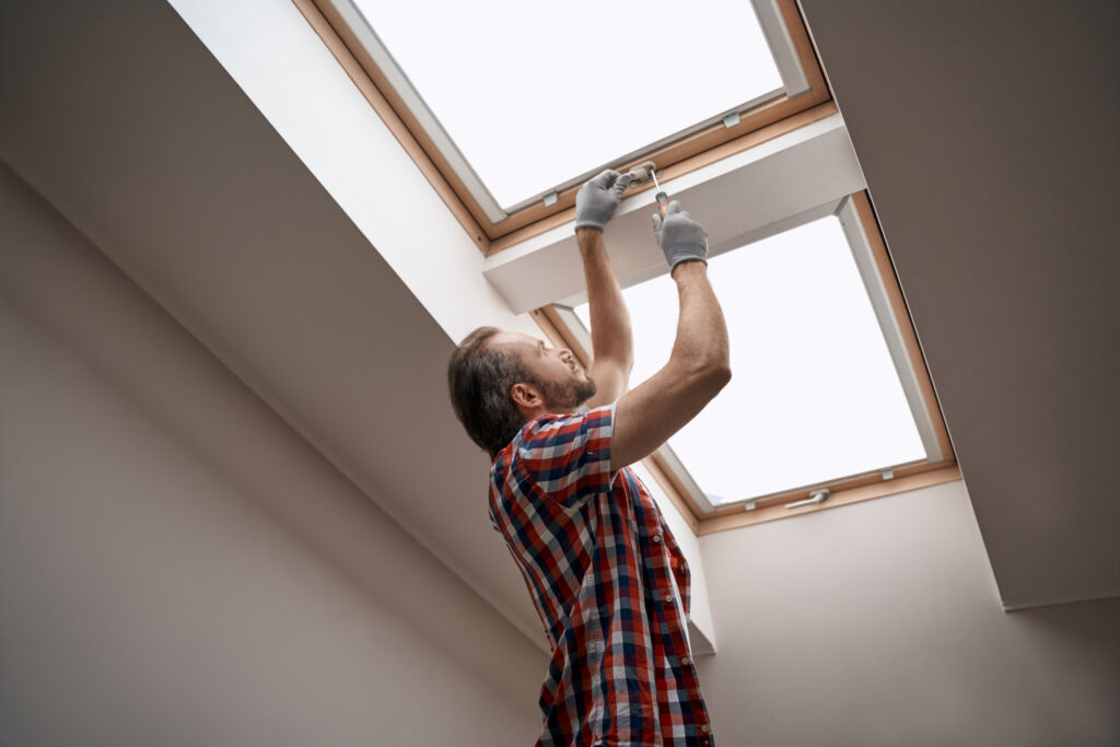 Home remodeling service worker installing new skylights in a home's roof